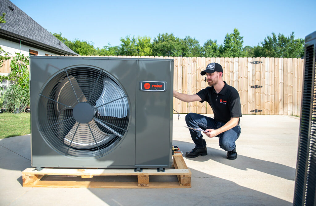 HVAC technician working on an outdoor air conditioner